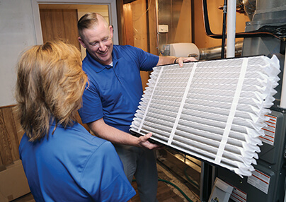 A technician showing a client a air quality filter.